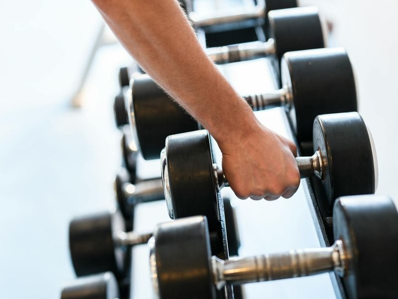 Close up of a man hands gripping a heavy dumbbell.