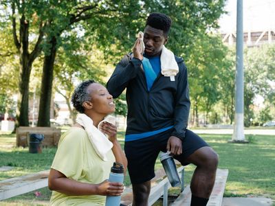 Water bottle and towel on a gym bench.